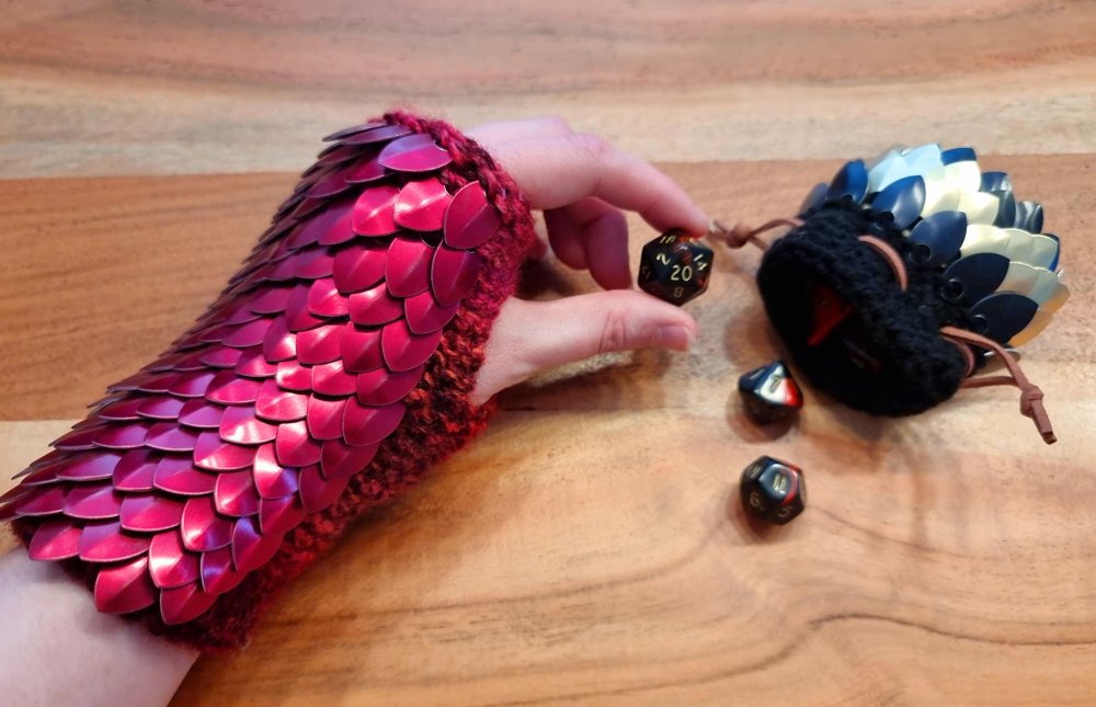 Red wrist length gloves worn while holding a d20 near a scale dice pouch